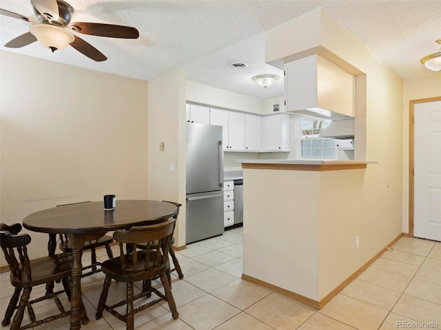 kitchen featuring white cabinets, ceiling fan, a textured ceiling, appliances with stainless steel finishes, and kitchen peninsula