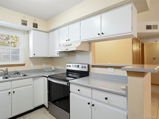 kitchen with stainless steel range with electric stovetop, white cabinets, sink, light tile patterned flooring, and kitchen peninsula