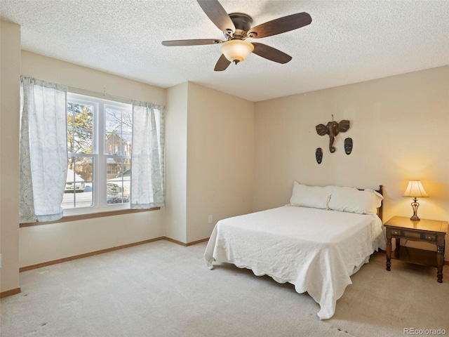 carpeted bedroom with ceiling fan and a textured ceiling