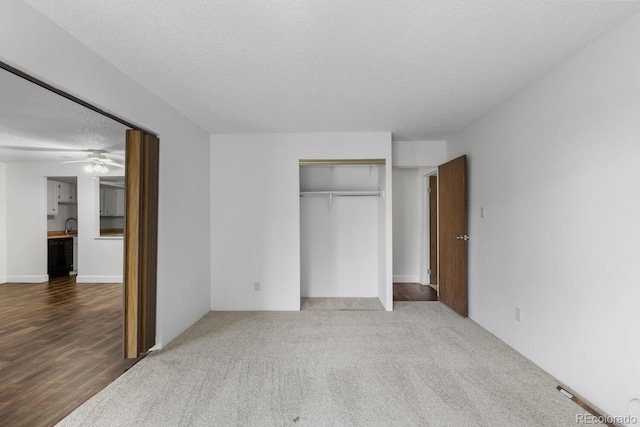 unfurnished bedroom featuring hardwood / wood-style flooring, a closet, and a textured ceiling