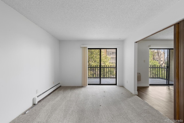 spare room with wood-type flooring, a baseboard heating unit, and a textured ceiling