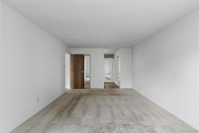 unfurnished room featuring a textured ceiling and carpet flooring