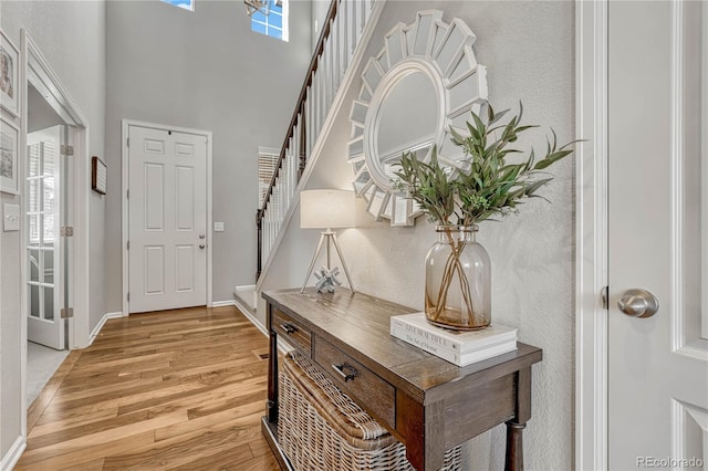 foyer with a high ceiling and light hardwood / wood-style floors