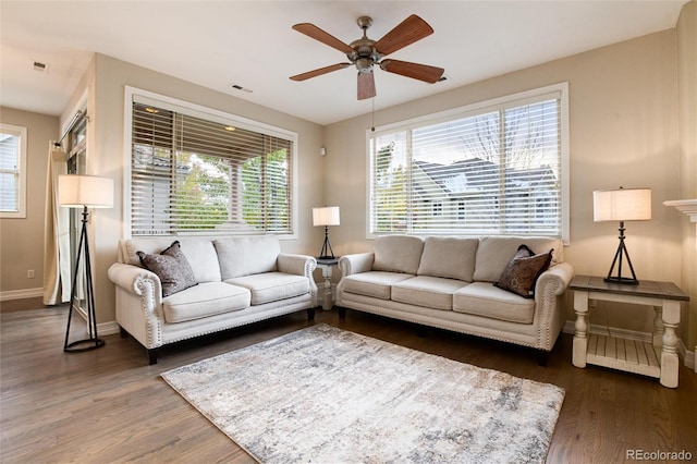 living room featuring ceiling fan and dark wood-type flooring