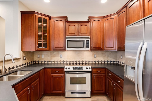 kitchen with decorative backsplash, appliances with stainless steel finishes, and sink