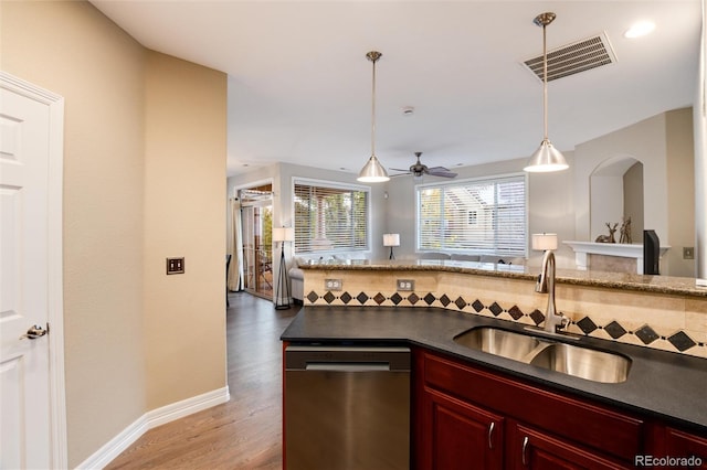 kitchen with ceiling fan, sink, hanging light fixtures, stainless steel dishwasher, and wood-type flooring