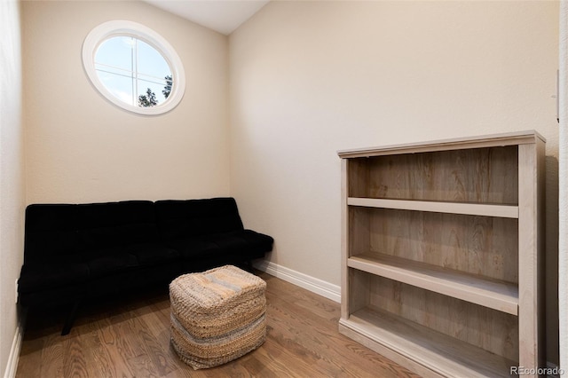 living area featuring vaulted ceiling and hardwood / wood-style flooring