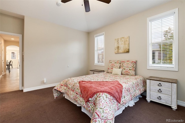 bedroom featuring multiple windows, ceiling fan, and dark carpet