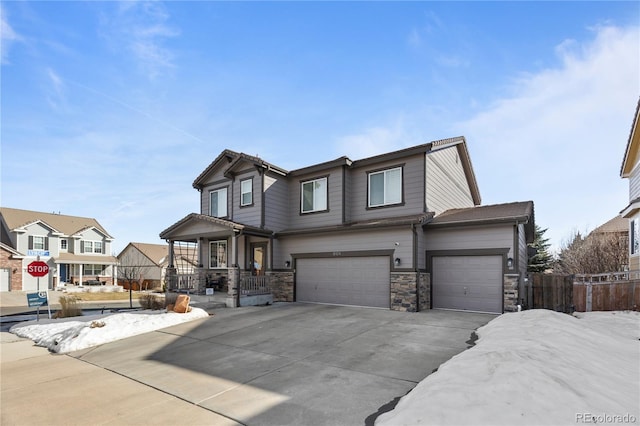 view of front of property featuring fence, a porch, a garage, stone siding, and driveway