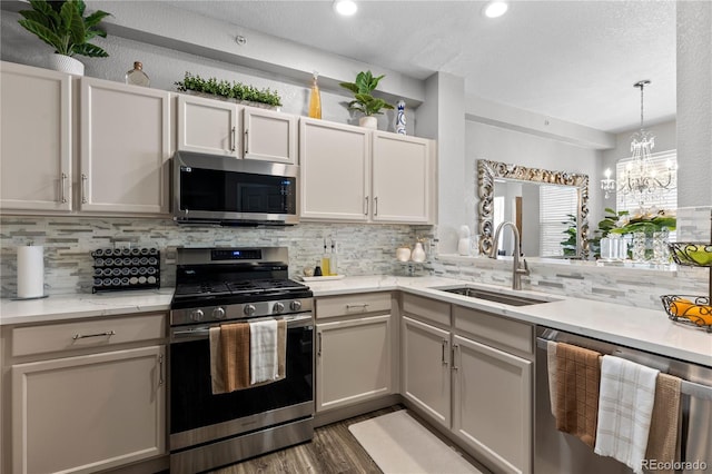 9758 Laredo St Unit 18D, Commerce City, CO 80022 - kitchen with a sink, a notable chandelier, tasteful backsplash, and stainless steel appliances
