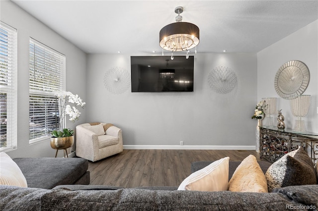 9758 Laredo St Unit 18D, Commerce City, CO 80022 - living area featuring baseboards, a wealth of natural light, wood finished floors, and a notable chandelier