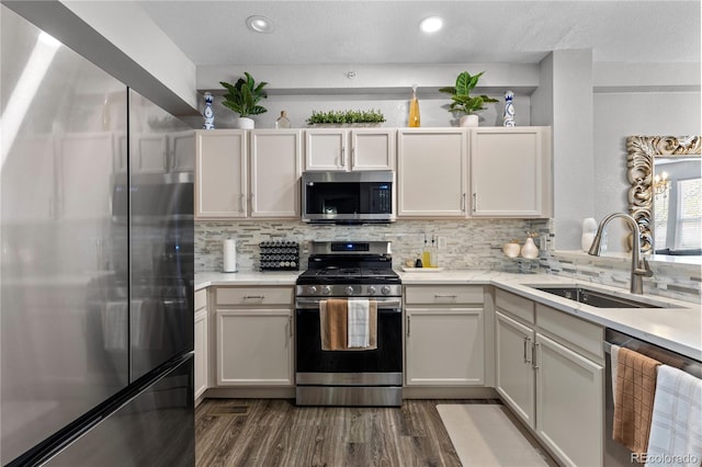 9758 Laredo St Unit 18D, Commerce City, CO 80022 - kitchen featuring dark wood-style flooring, appliances with stainless steel finishes, tasteful backsplash, a sink, and light countertops