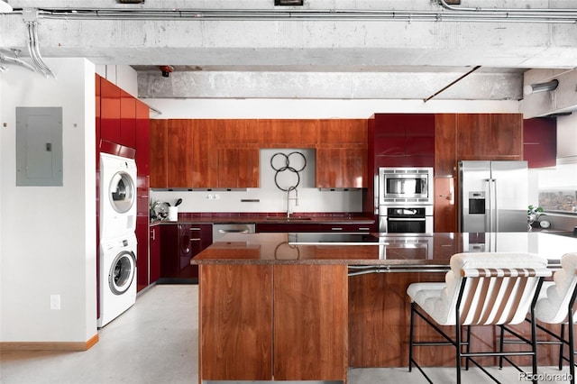 100 Park Ave Unit 2008, Denver, CO 80205 - kitchen featuring stainless steel appliances, stacked washer / dryer, electric panel, dark countertops, and modern cabinets