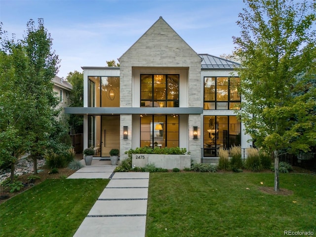 rear view of property featuring a lawn