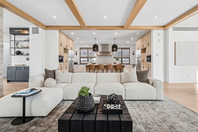 living room featuring beam ceiling and light hardwood / wood-style floors