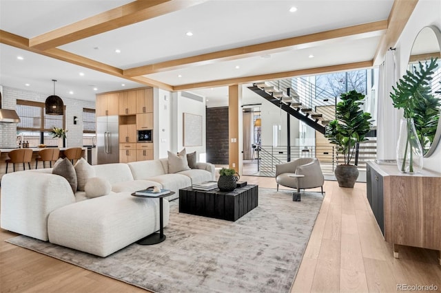 living room featuring beamed ceiling and light wood-type flooring