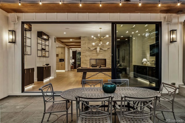 dining space featuring rail lighting, a chandelier, and a fireplace