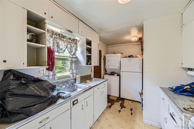 10040 W 13th Pl, Lakewood, CO 80215 - kitchen with freestanding refrigerator, stacked washer / dryer, open shelves, and white cabinets