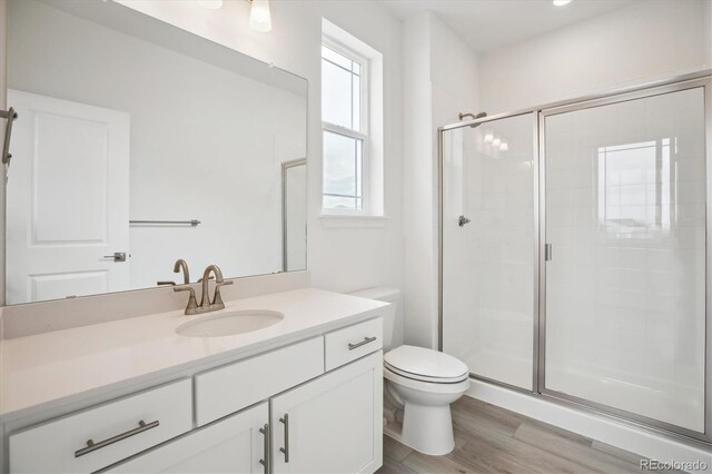 8245 Butte Creek St, Littleton, CO 80125 - full bath with a shower stall, vanity, toilet, and wood finished floors
