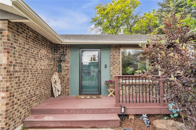 3163 S Boston Ct, Denver, CO 80231 - property entrance featuring brick siding, a shingled roof, and a deck