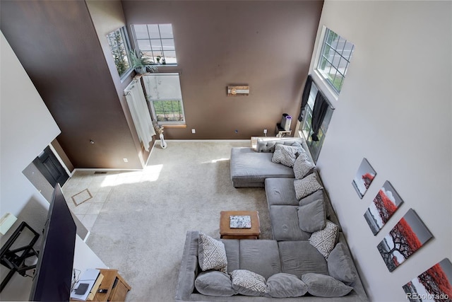 carpeted living room featuring a high ceiling and plenty of natural light