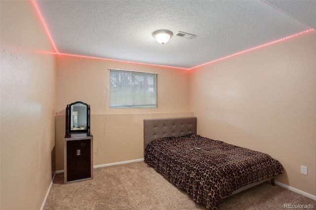 bedroom featuring a textured ceiling and light carpet