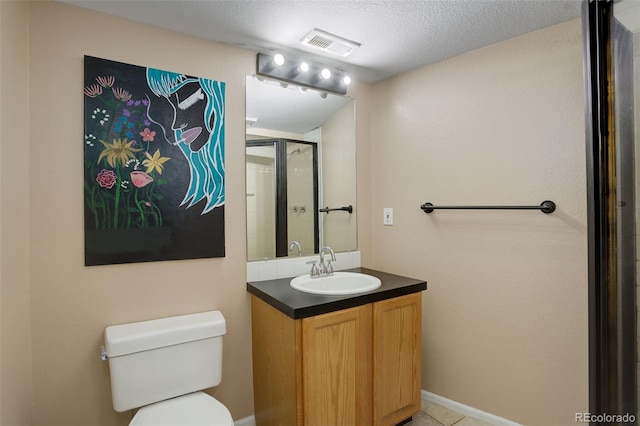 bathroom with tile patterned floors, a textured ceiling, toilet, vanity, and a shower with shower door