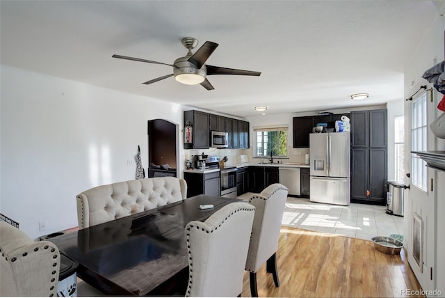 dining area featuring light hardwood / wood-style flooring, ceiling fan, and sink