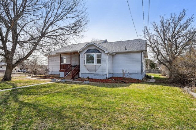 view of front of house with a shingled roof and a front lawn