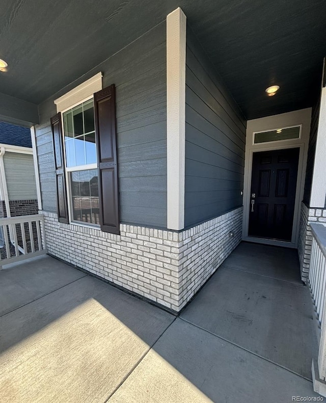 view of exterior entry with covered porch