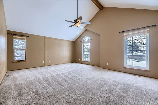 carpeted spare room featuring beam ceiling, high vaulted ceiling, plenty of natural light, and ceiling fan