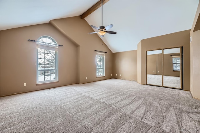 interior space featuring ceiling fan, beamed ceiling, and a healthy amount of sunlight