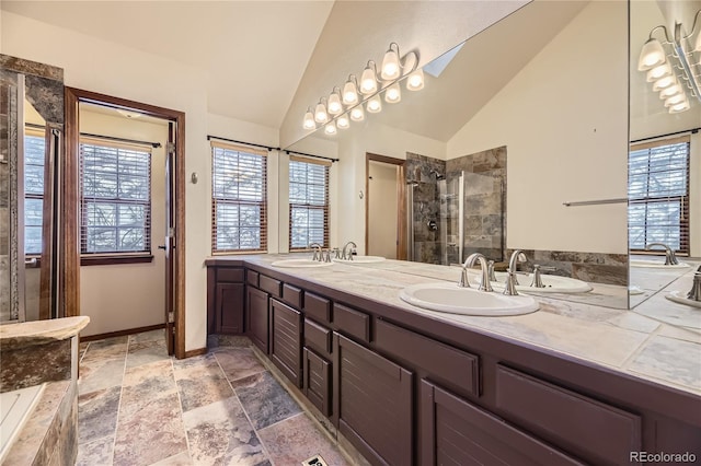 bathroom featuring vanity, a shower with door, and vaulted ceiling