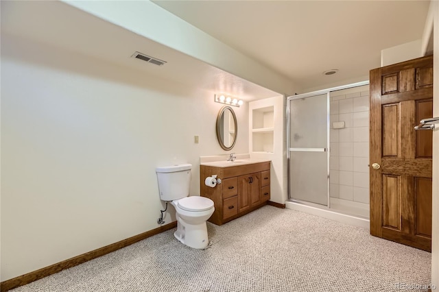 bathroom with a shower with door, vanity, and toilet