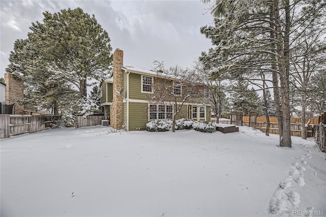 view of snow covered back of property