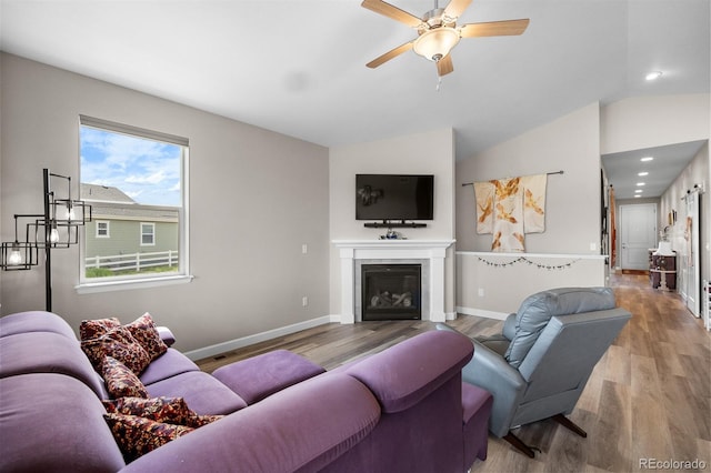 2060 Peralta Loop, Castle Rock, CO 80104 - living room featuring wood finished floors, ceiling fan, a glass covered fireplace, baseboards, and vaulted ceiling