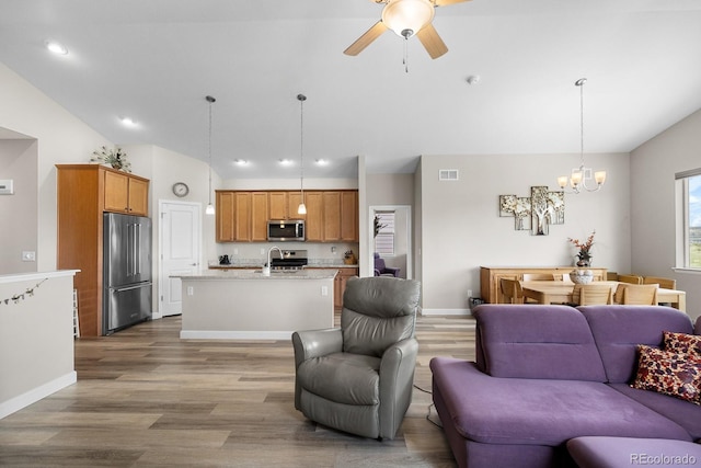 2060 Peralta Loop, Castle Rock, CO 80104 - living area with lofted ceiling, wood finished floors, a chandelier, ceiling fan, and baseboards