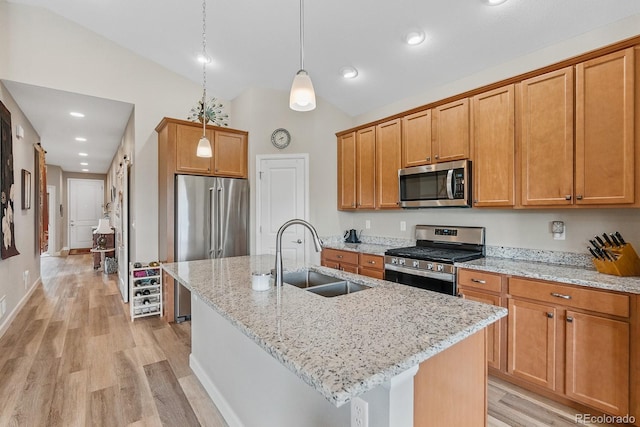2060 Peralta Loop, Castle Rock, CO 80104 - kitchen featuring stainless steel appliances, a sink, lofted ceiling, light wood-style flooring, and a kitchen island with sink