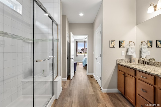 2060 Peralta Loop, Castle Rock, CO 80104 - ensuite bathroom with a shower stall, wood finished floors, vanity, recessed lighting, and baseboards
