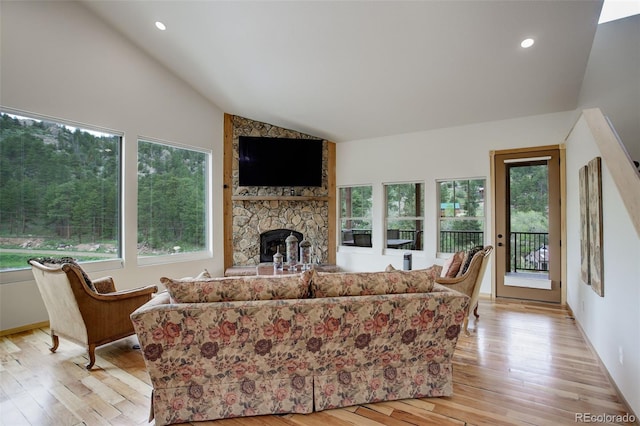 178 Cree Ct, Lyons, CO 80540 - living area with healthy amount of natural light, lofted ceiling, a stone fireplace, light wood finished floors, and recessed lighting