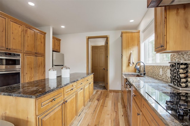 178 Cree Ct, Lyons, CO 80540 - kitchen with stainless steel appliances, light wood-style flooring, backsplash, dark stone countertops, and recessed lighting
