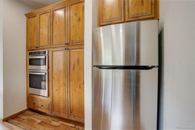 178 Cree Ct, Lyons, CO 80540 - kitchen featuring appliances with stainless steel finishes, light wood-style flooring, and brown cabinetry