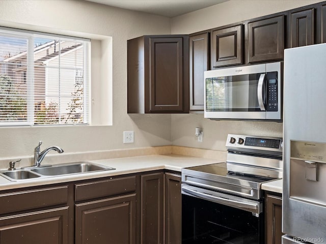 kitchen featuring dark brown cabinets, stainless steel appliances, and sink