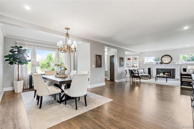 dining space with ornamental molding, hardwood / wood-style floors, a notable chandelier, and built in shelves