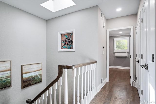 hall featuring dark wood-type flooring and a skylight