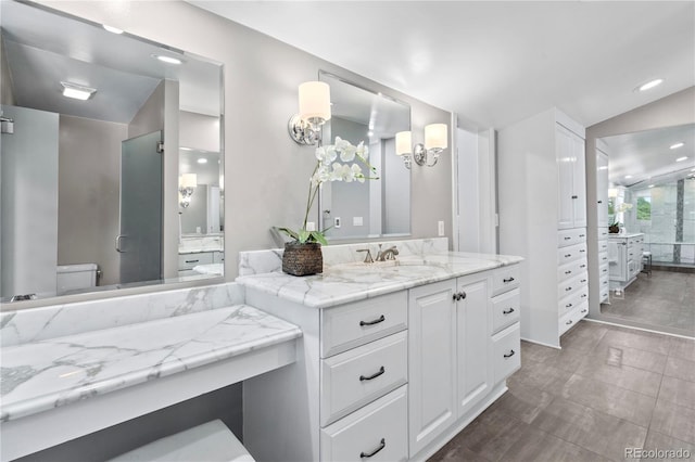 bathroom featuring vanity, vaulted ceiling, and toilet