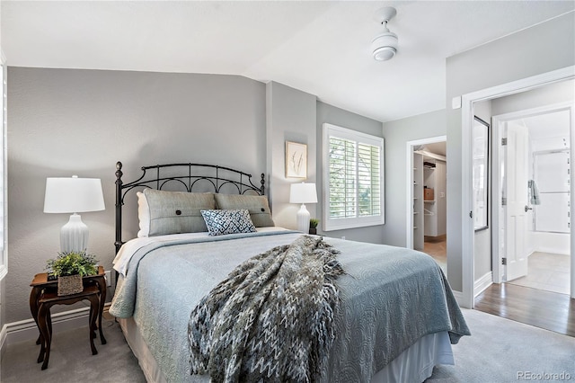 carpeted bedroom featuring lofted ceiling, ceiling fan, and ensuite bathroom