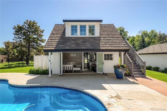 back of house featuring a fenced in pool, an outdoor structure, a patio, and a lawn