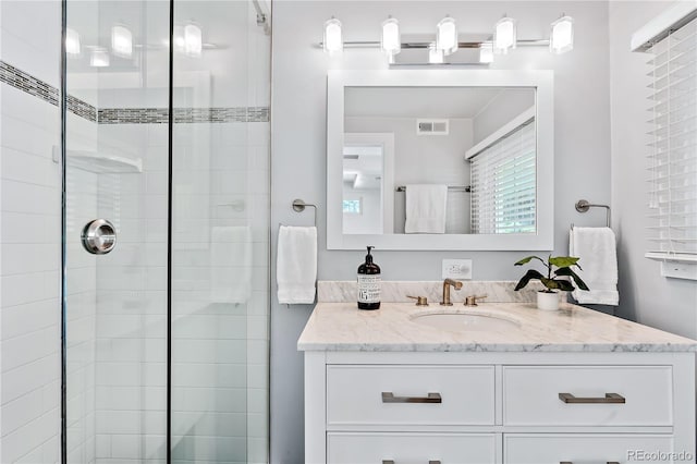 bathroom with vanity and a tile shower