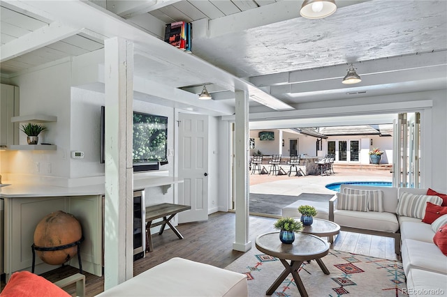 living room featuring beam ceiling, hardwood / wood-style floors, and wooden ceiling